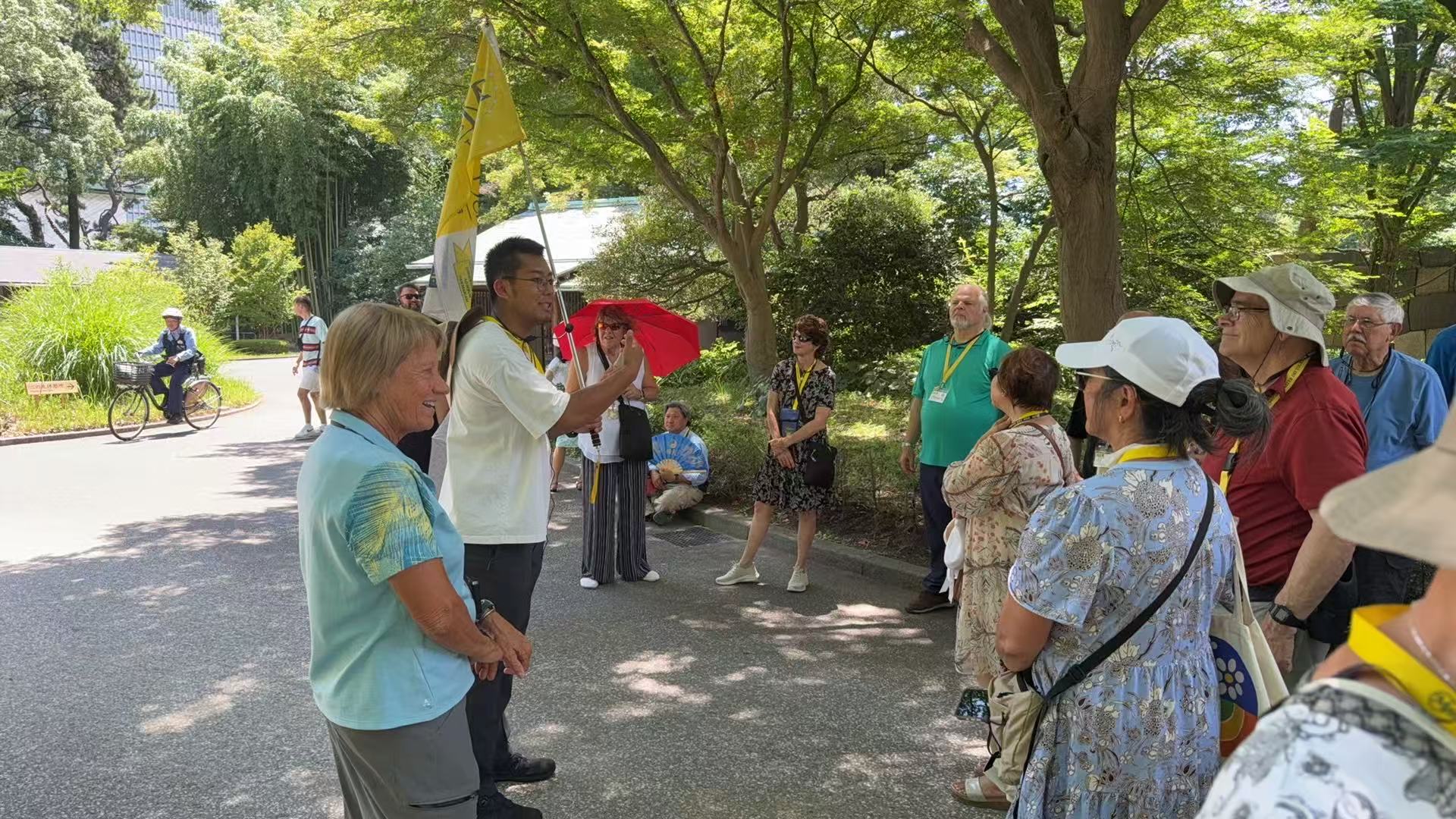 Past pilgrims listening to their guide during a garden visit in Japan