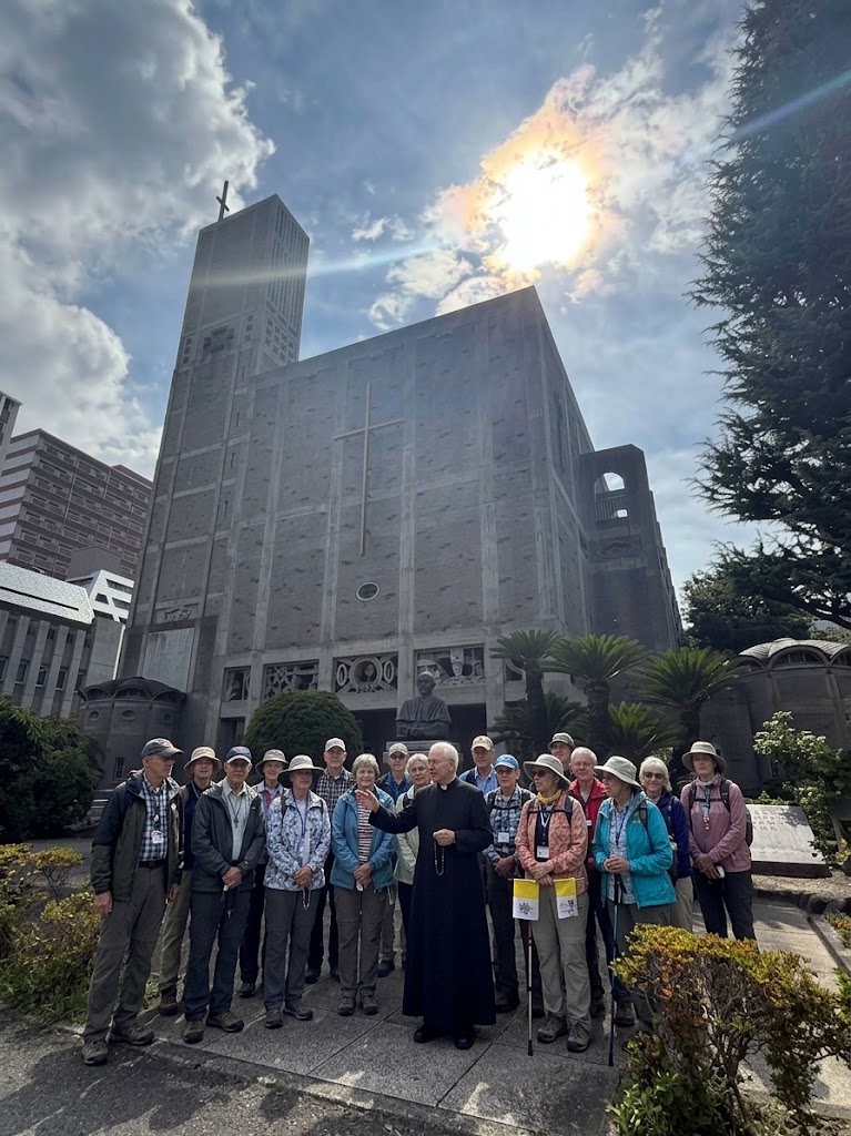 Pilgrimage group with a priest outside a Catholic church in Japan