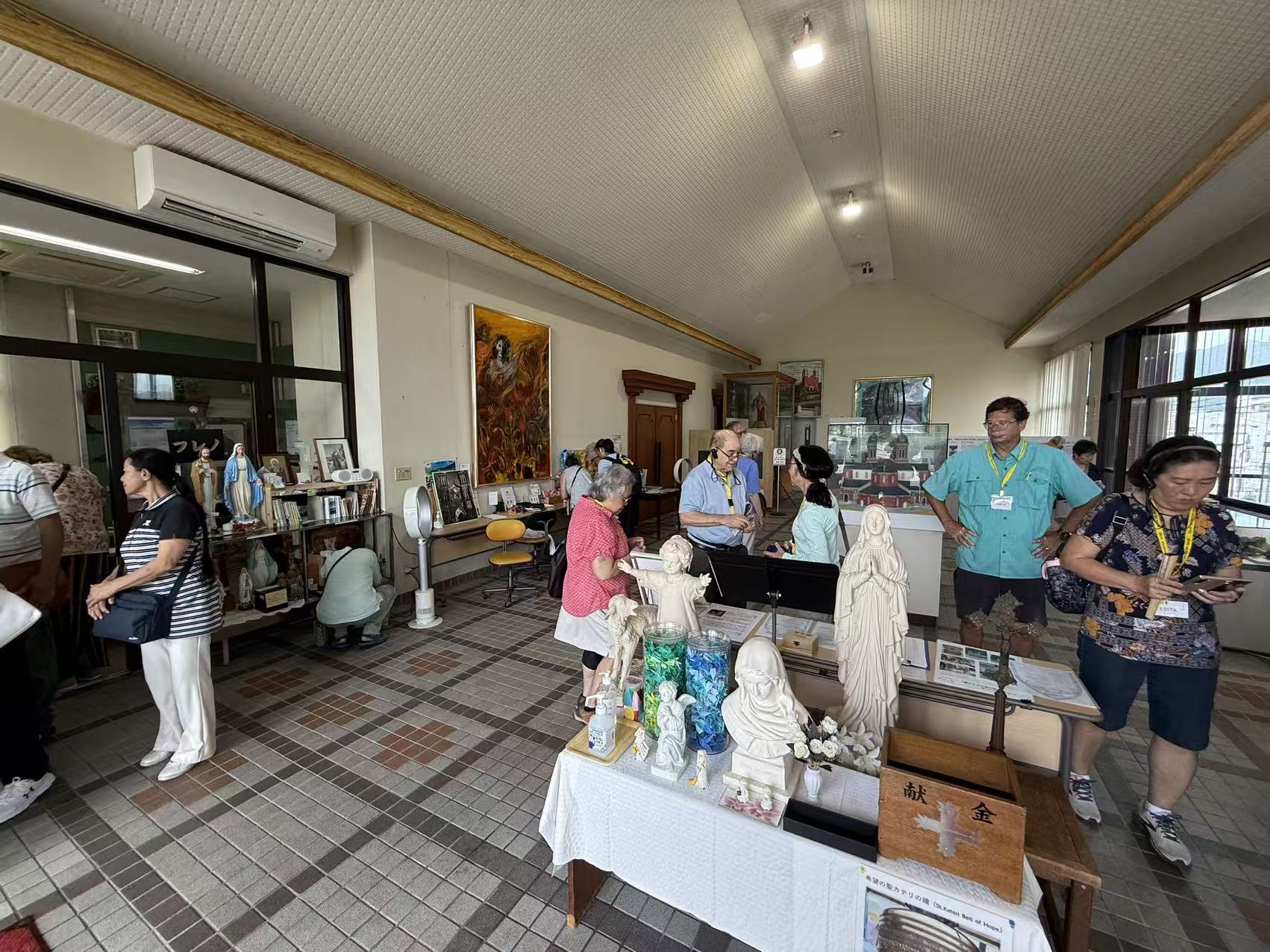 Pilgrims exploring a Catholic heritage room with devotional objects and historical displays