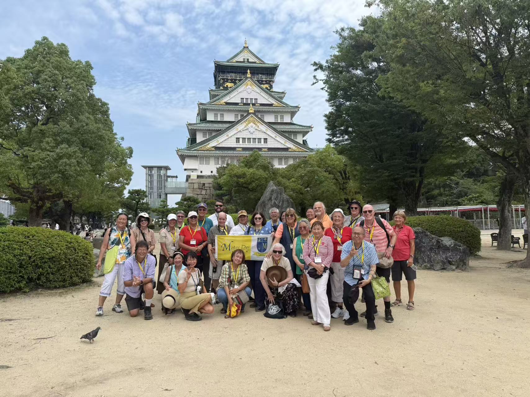 Pilgrimage group posing together in front of Osaka Castle