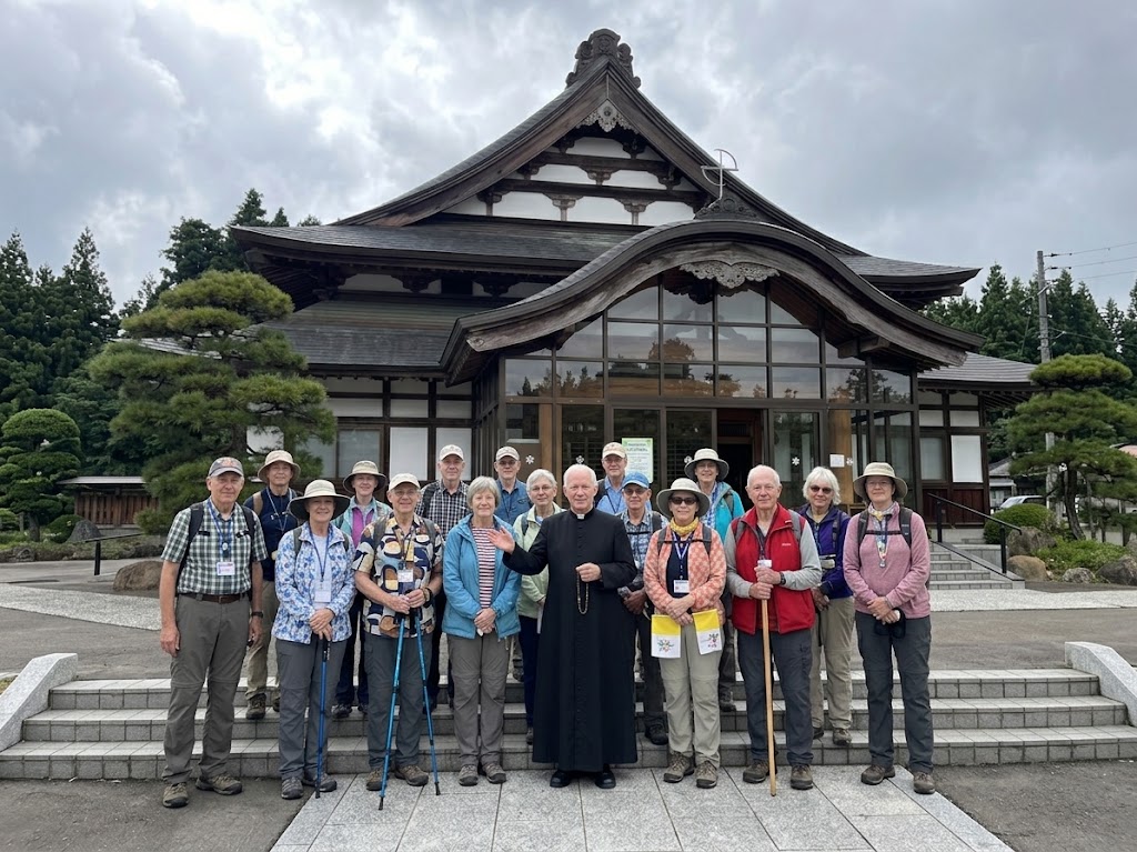 Pilgrims with a priest outside a historic building in Japan